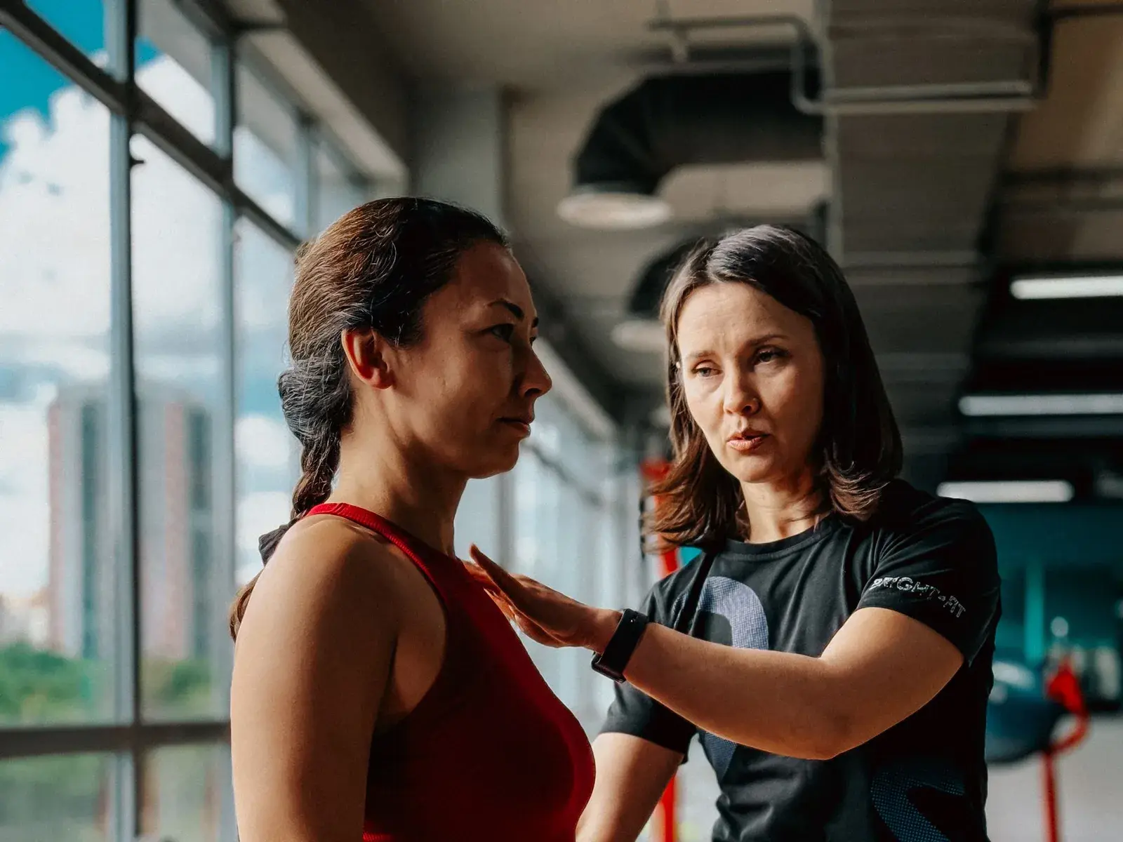 Entrenadora personal preparando sus tarifas con una calculadora en el gimnasio